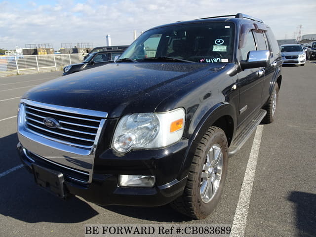 A grey sports car speeding down a highway at night.