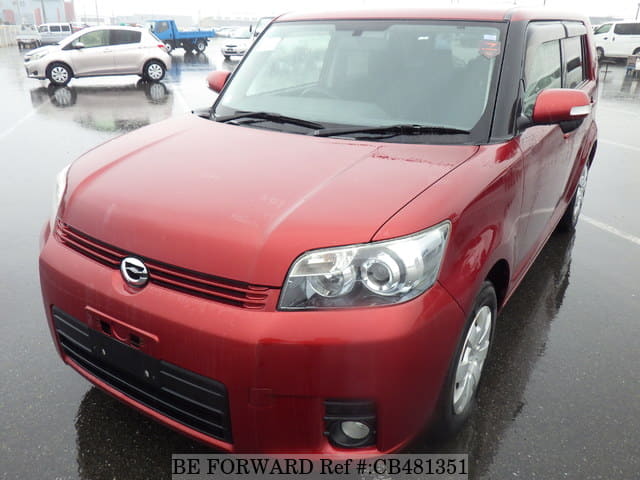 A grey JDM sports car speeding down a highway at night.
