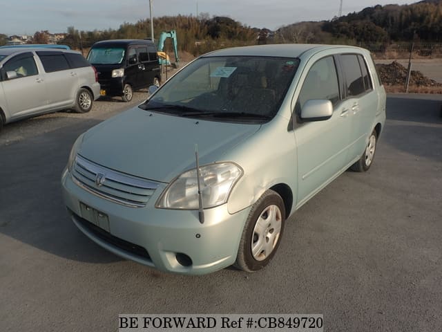 A grey JDM sports car speeding down a highway at night.