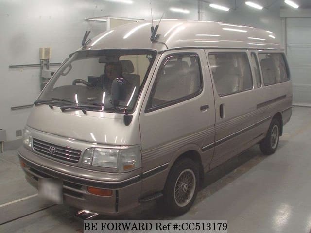 A grey sports car speeding down a highway at night.