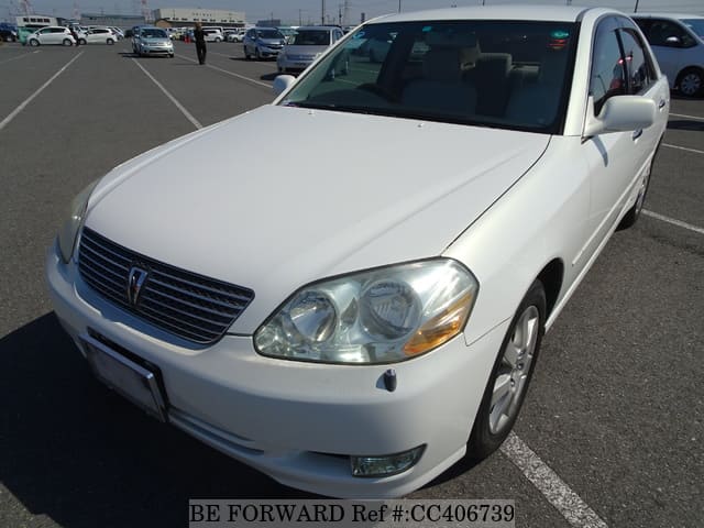 A grey JDM sports car speeding down a highway at night.