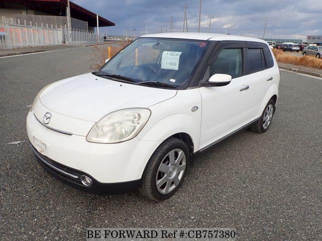 A grey JDM sports car speeding down a highway at night.