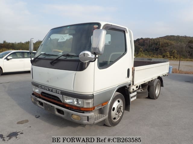 A grey JDM sports car speeding down a highway at night.