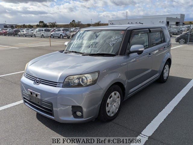A grey JDM sports car speeding down a highway at night.