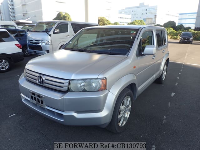 A grey JDM sports car speeding down a highway at night.
