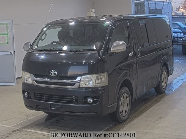 A grey sports car speeding down a highway at night.