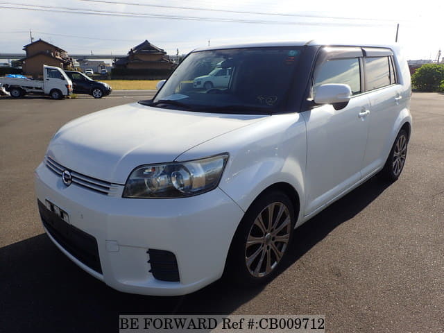 A grey JDM sports car speeding down a highway at night.
