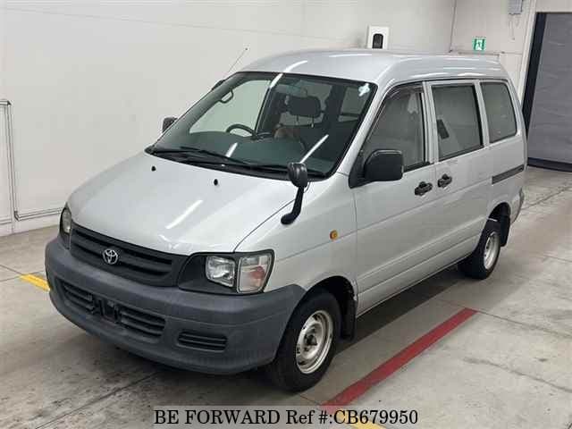 A grey JDM sports car speeding down a highway at night.