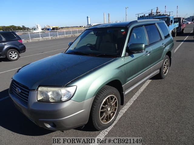 A grey sports car speeding down a highway at night.