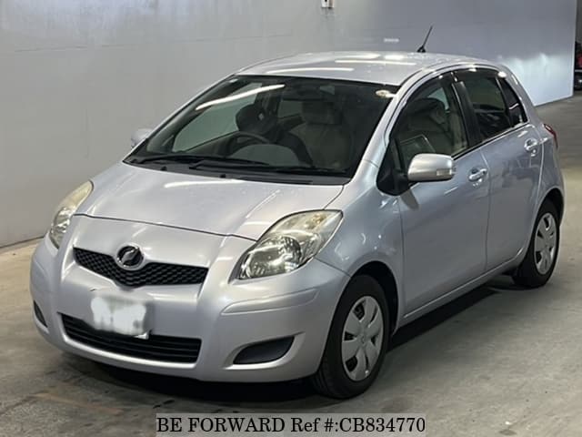 A grey JDM sports car speeding down a highway at night.