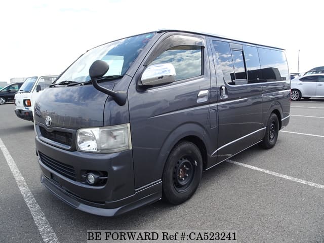 A grey JDM sports car speeding down a highway at night.