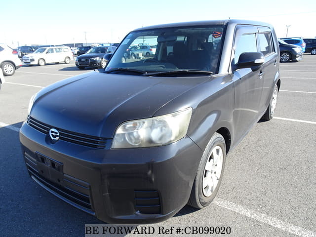 A grey sports car speeding down a highway at night.