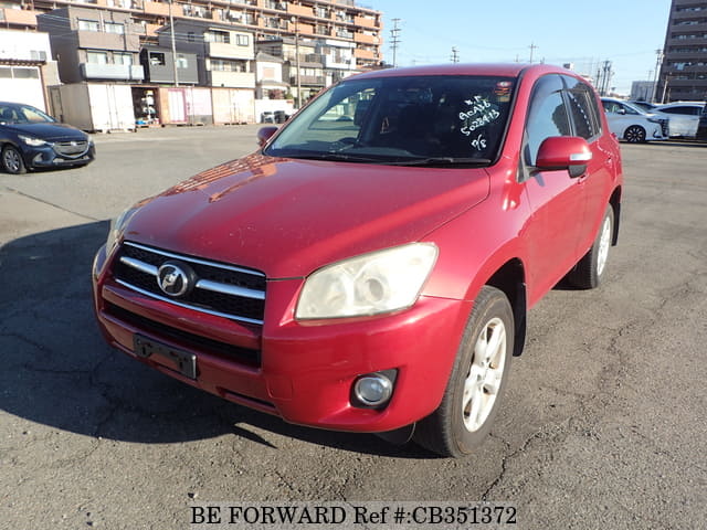 A grey JDM sports car speeding down a highway at night.