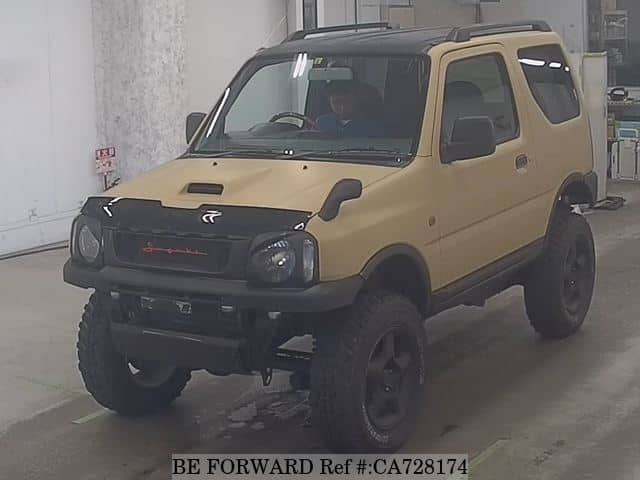 A grey JDM sports car speeding down a highway at night.