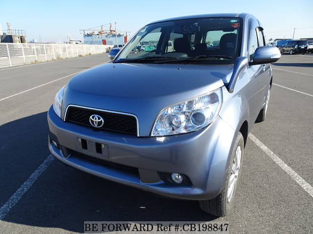 A grey JDM sports car speeding down a highway at night.