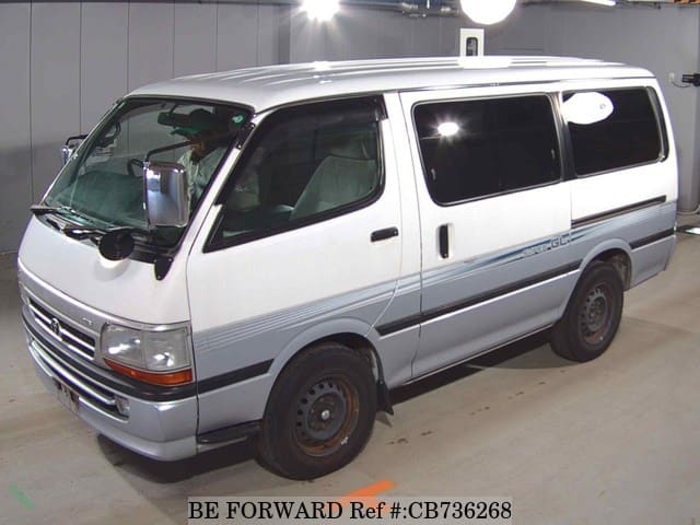 A grey JDM sports car speeding down a highway at night.