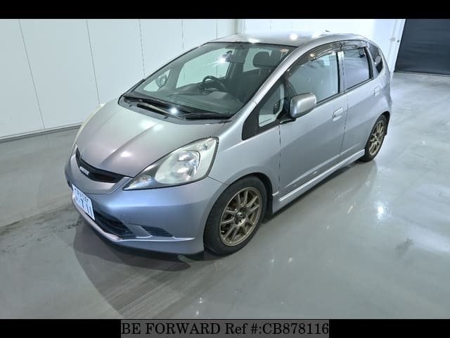 A grey JDM sports car speeding down a highway at night.