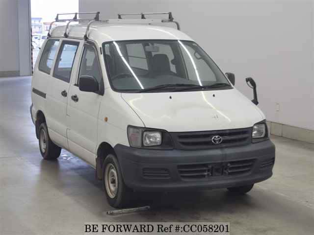 A grey sports car speeding down a highway at night.