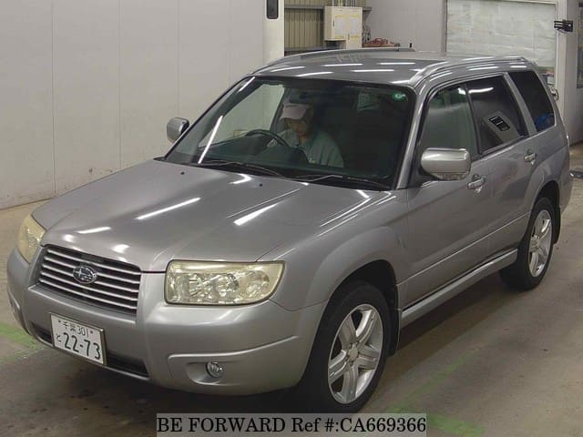 A grey JDM sports car speeding down a highway at night.