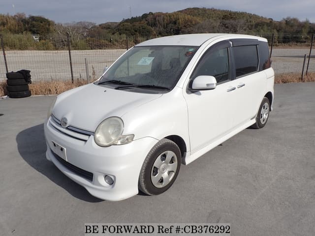 A grey sports car speeding down a highway at night.