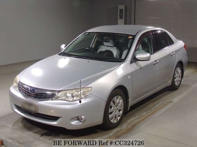 A grey sports car speeding down a highway at night.