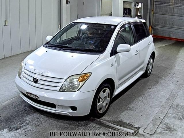 A grey JDM sports car speeding down a highway at night.