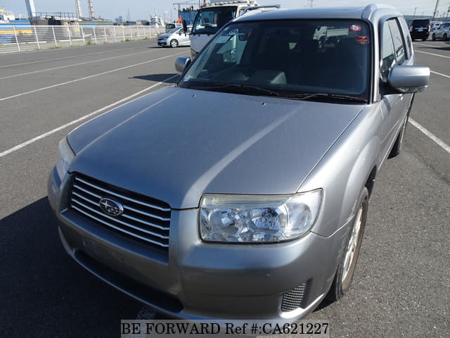 A grey JDM sports car speeding down a highway at night.