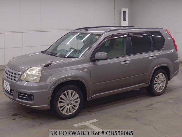 A grey sports car speeding down a highway at night.