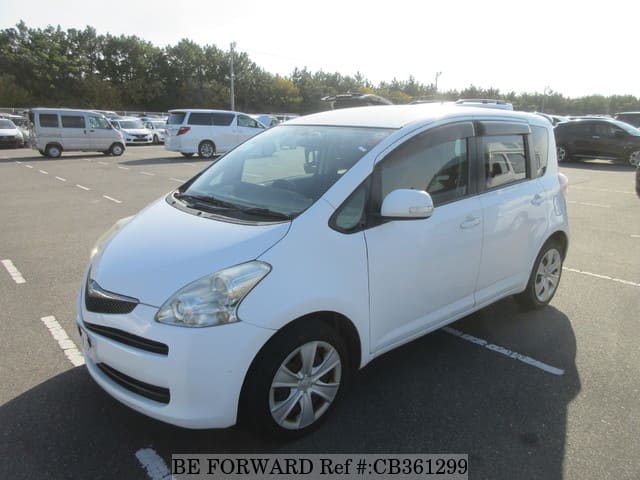 A grey JDM sports car speeding down a highway at night.