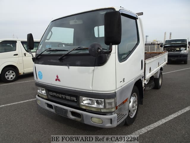 A grey JDM sports car speeding down a highway at night.