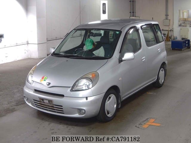 A grey JDM sports car speeding down a highway at night.
