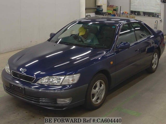 A grey JDM sports car speeding down a highway at night.