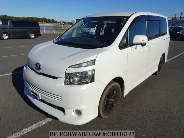 A grey JDM sports car speeding down a highway at night.