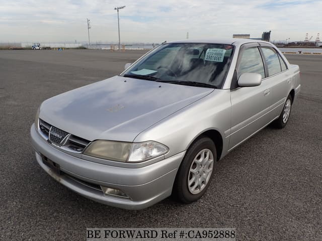 A grey JDM sports car speeding down a highway at night.