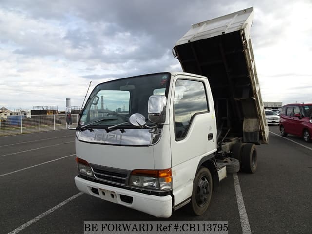 A grey JDM sports car speeding down a highway at night.