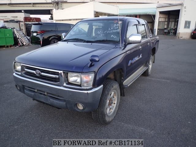 A grey JDM sports car speeding down a highway at night.