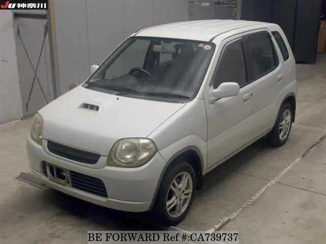 A grey JDM sports car speeding down a highway at night.