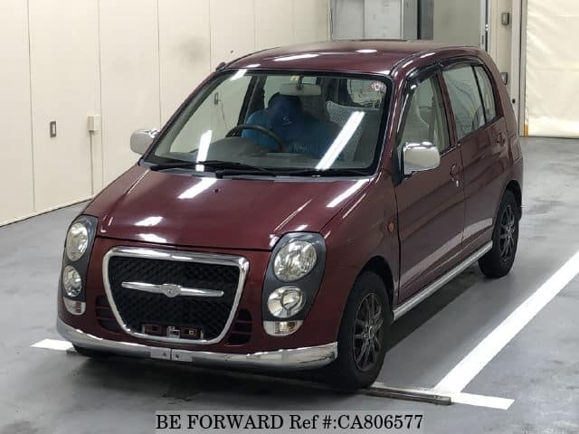 A grey JDM sports car speeding down a highway at night.