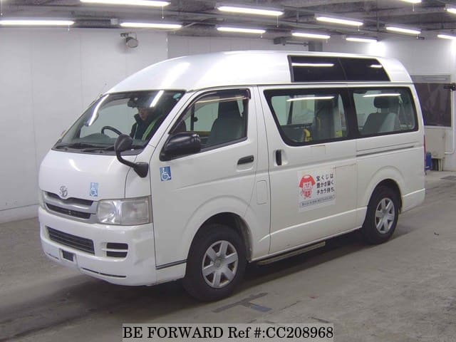 A grey sports car speeding down a highway at night.