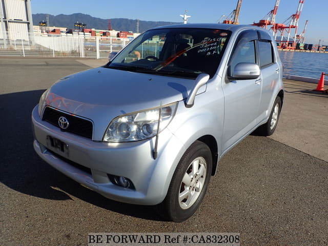 A grey JDM sports car speeding down a highway at night.