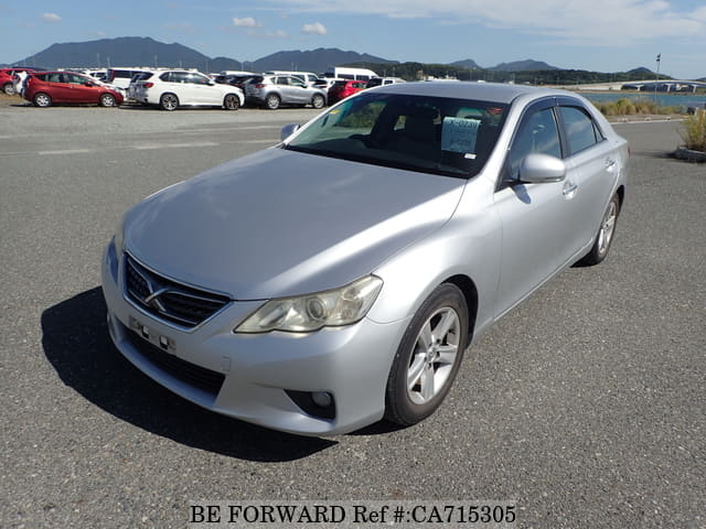 A grey JDM sports car speeding down a highway at night.