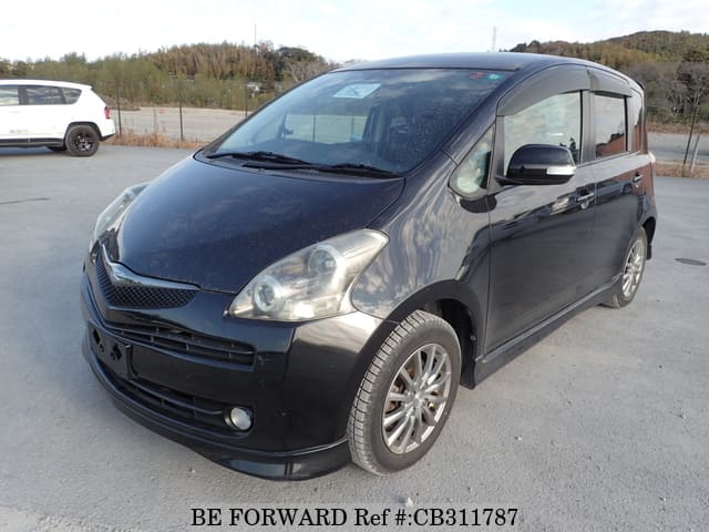 A grey JDM sports car speeding down a highway at night.