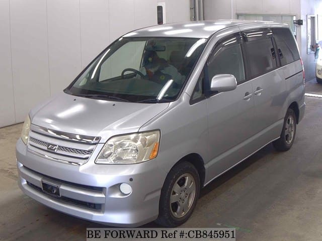 A grey JDM sports car speeding down a highway at night.