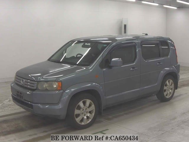 A grey JDM sports car speeding down a highway at night.