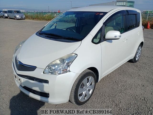 A grey JDM sports car speeding down a highway at night.
