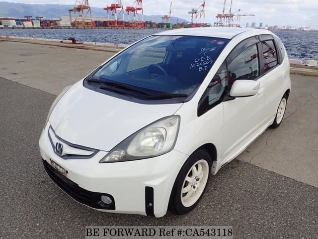 A grey JDM sports car speeding down a highway at night.