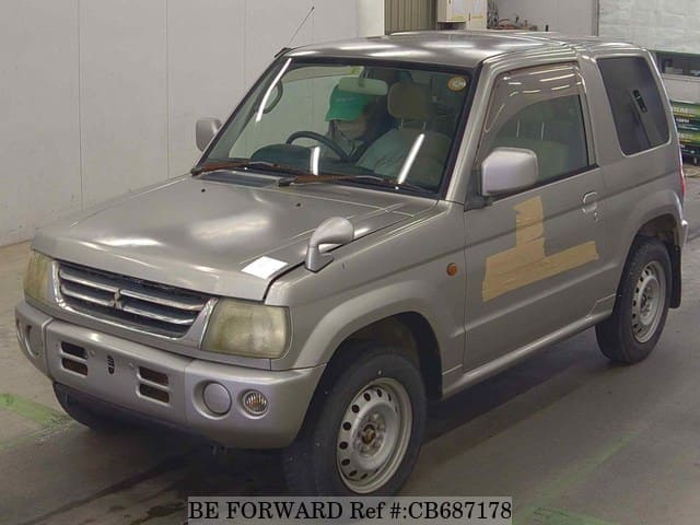 A grey JDM sports car speeding down a highway at night.