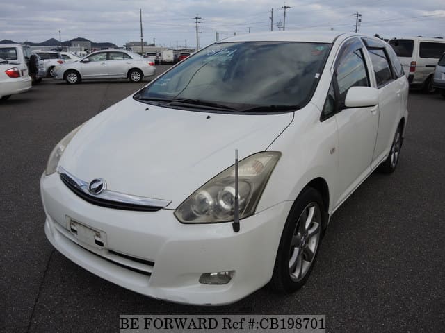 A grey JDM sports car speeding down a highway at night.