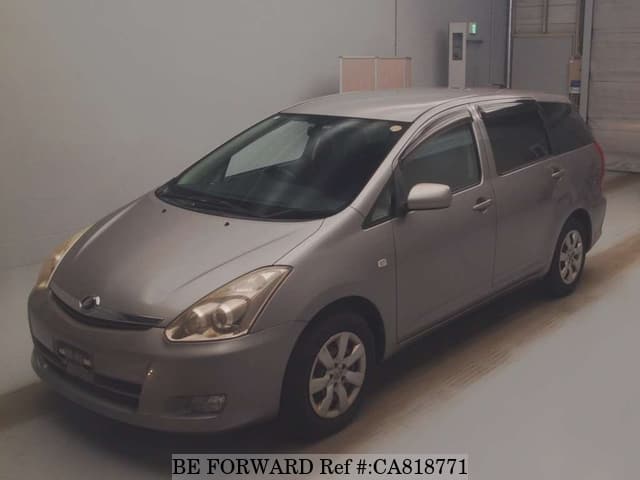 A grey JDM sports car speeding down a highway at night.