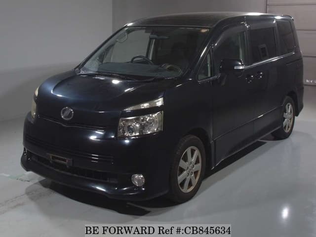 A grey JDM sports car speeding down a highway at night.